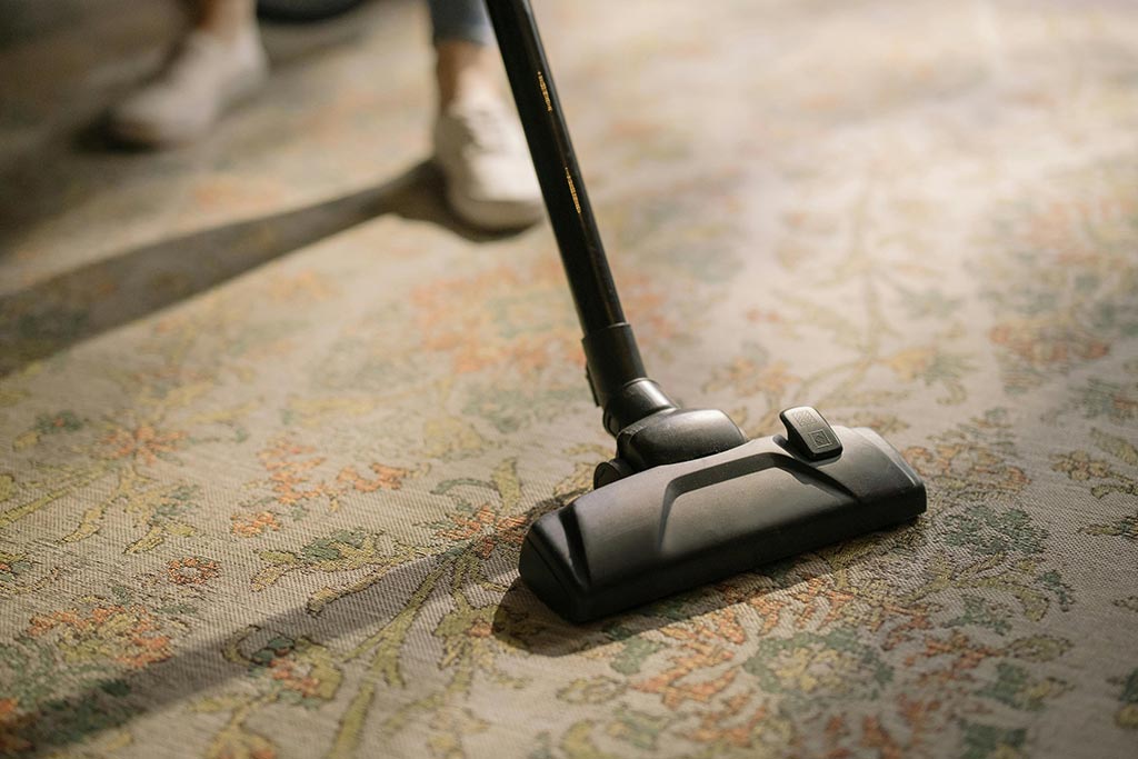 A person is vacuuming a carpet